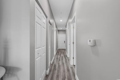 Hall featuring baseboards, recessed lighting, and wood finished floors