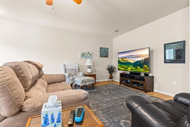Living area featuring ceiling fan, baseboards, vi