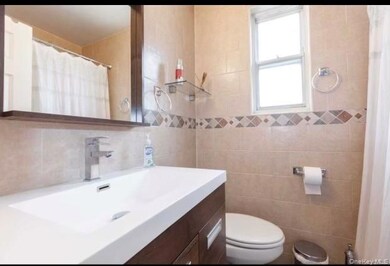Bathroom featuring curtained shower, vanity, and tile walls