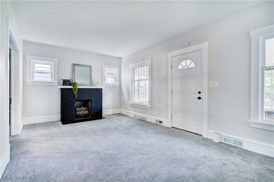 Entryway with carpet floors, a brick fireplace, a textured ceiling, and baseboards