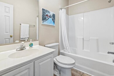 Full bath with toilet, tile patterned floors, show