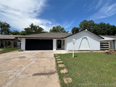 Single story home featuring brick siding, a garage