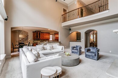 Carpeted living room featuring ornamental molding and a towering ceiling