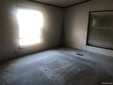 Carpeted empty room with wallpapered walls and crown molding