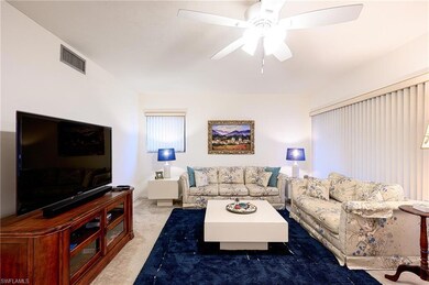 Living room with ceiling fan and light carpet