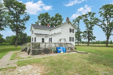 Back of house with a yard, a chimney, and a deck