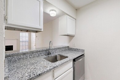 Kitchen featuring white cabinetry, a sink, light s