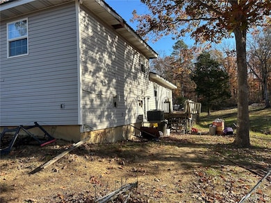View of side of home with a wooden deck and a cooling unit