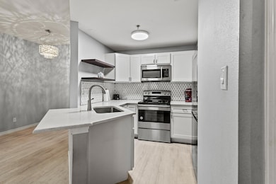 Kitchen featuring white cabinets, appliances with 