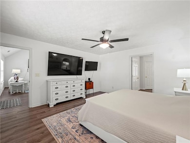 Bedroom with baseboards, a ceiling fan, a textured