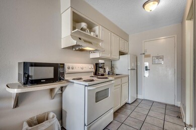 Kitchen featuring light countertops, light tile pa