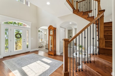 Entryway with arched walkways, a high ceiling, and stairs