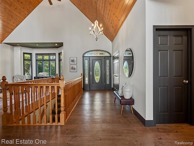 Entryway with high vaulted ceiling, wood-type flooring, a chandelier, and wood ceiling
