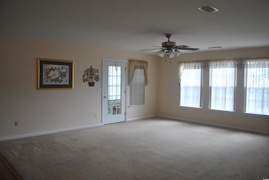 Empty room featuring carpet, baseboards, and a ceiling fan