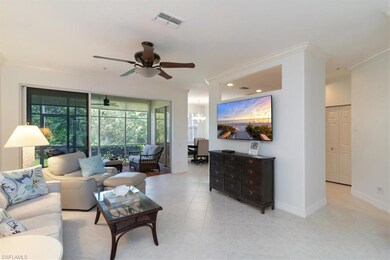 Living room with crown molding, light tile floors,