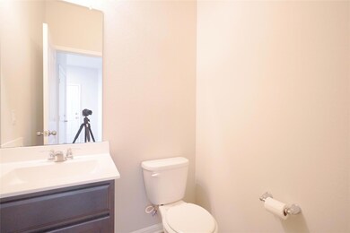 Bathroom featuring toilet, vanity, and baseboards