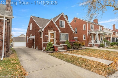 View of front of house featuring brick siding, an outdoor structure, roof with shingles, and a detached garage