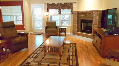 Living room has laminate flooring and a gas log fireplace.