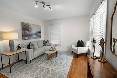 Living area with light wood-style flooring and ornamental molding