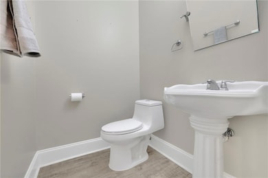 Half bath featuring baseboards and light wood finished floors