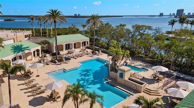 Pool with a water view, fence, and a patio area