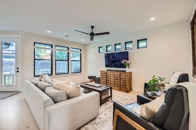 Living area featuring a ceiling fan, recessed lig