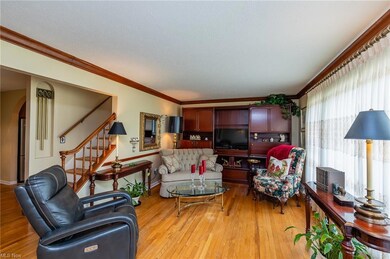 Living room with hardwood flooring and crown moldi