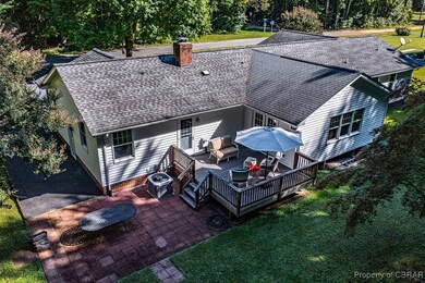 Back of property with a chimney, central AC, a dec