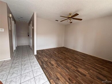 Empty room featuring a textured ceiling, ceiling fan, and light hardwood / wood-style flooring