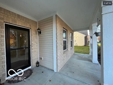view of exterior entry with brick siding and a patio area