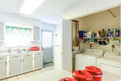 Laundry area with washer and clothes dryer, wallpapered walls, and light tile patterned floors