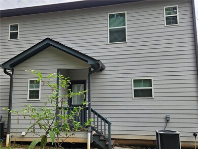 Rear view of property featuring central AC