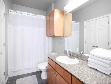Bathroom with vanity, dark tile patterned floors, and shower / bath combo with shower curtain