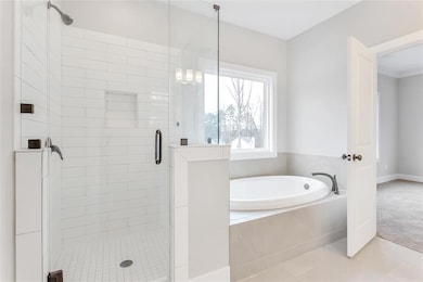 Bathroom featuring a bath, a shower stall, and tile patterned floors