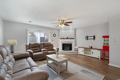 Living room with a textured ceiling, a brick firep