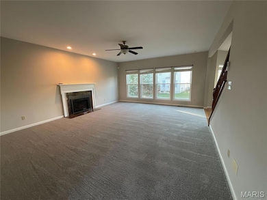 Unfurnished living room with recessed lighting, a fireplace with flush hearth, carpet flooring, and ceiling fan