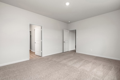 Empty room featuring light colored carpet and baseboards