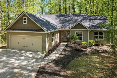 View of front facade featuring concrete driveway, a garage, and a shingled roof