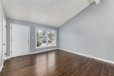 Living room with hardwood floor, vaulted ceiling a