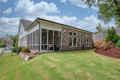 Back of property with a fenced backyard, a sunroom, and brick siding