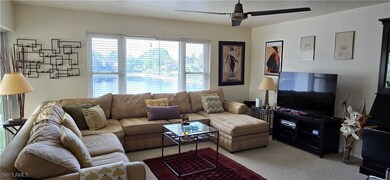 Carpeted living room featuring ceiling fan