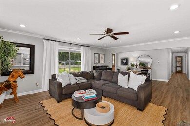 Living room featuring wood finished floors, a ceiling fan, recessed lighting, and crown molding