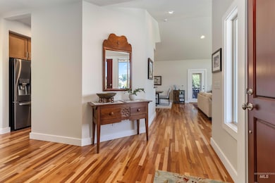 Entryway with light wood finished floors, vaulted ceiling, and recessed lighting