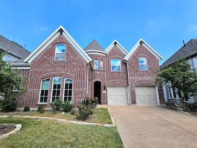 Traditional home with driveway, brick siding, a front lawn, and an attached garage