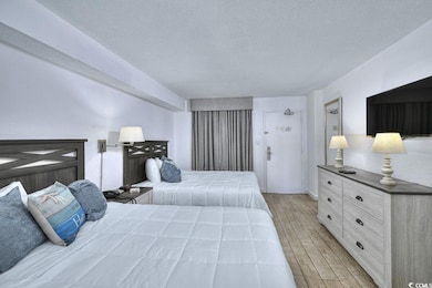 Bedroom with a textured ceiling and wood tiled flo