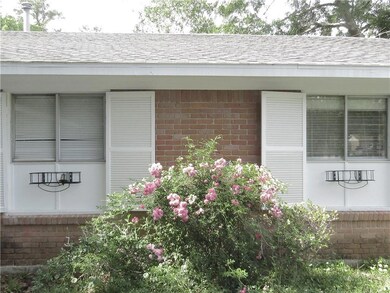 Side of home with flower baskets and working shutt