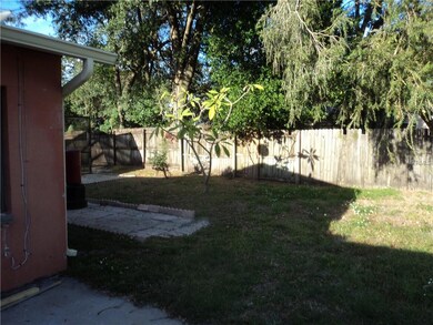 Partial view of fenced backyard & fruit tree