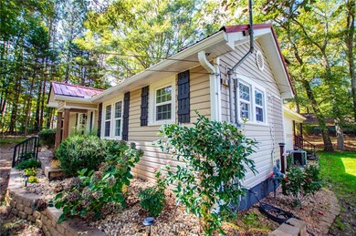 View of side of home with a metal roof and a porch