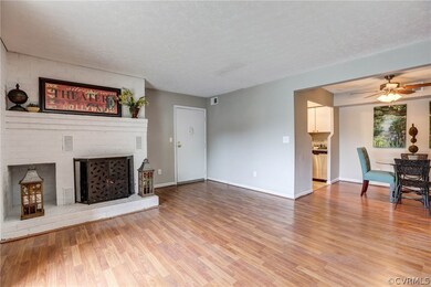 Impressive brick hearth fireplace, neutral grey paint, wood floors and bright, open floor plan!