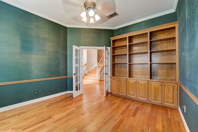 The study has gorgeous wood built-ins and plantation shutters